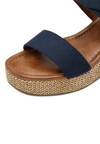 Sandales bleu marine avec deux larges straps, dotées d'une semelle intérieure en cuir texturé marron et d'une semelle en jute tressé.