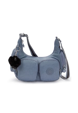 Blue crossbody bag with two front zip pockets, a black plush keychain, and adjustable striped shoulder strap against white background.