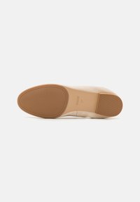 Scarpa décolleté nuda con tomaia in tessuto liscio e suola in gomma texturizzata. Presenta una punta arrotondata e un design minimalista.