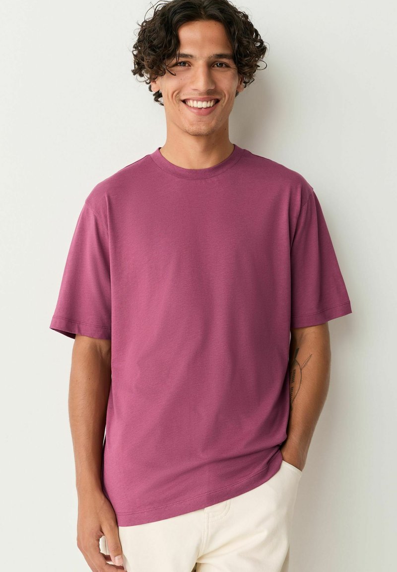 Kortærmet T-shirt med rund hals i dyb mauve, fremstillet af blød bomuldsblanding, med afslappet pasform og minimal syning.