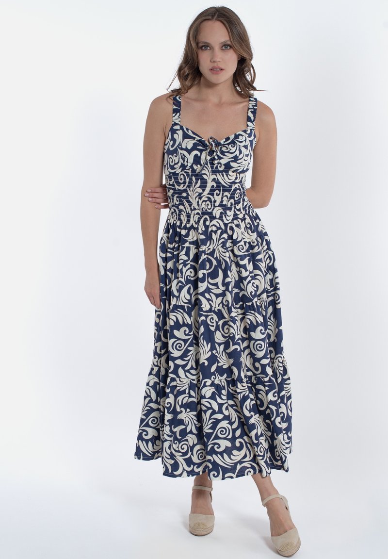 Abito lungo in tessuto a fiori blu navy con bustino aderente, spalline larghe e gonna a balze. Presenta un dettaglio annodato sul petto.