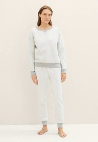 Lichtgrijze katoenen sweatshirt met een ronde hals en grijze manchetten, gecombineerd met bijpassende lichtgrijze joggingbroek met elastische boorden.