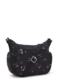 Svart tyg crossbody-väska med blommönster i lila och vitt. Har justerbar rem, dragkedjefickor och en strukturerad form.