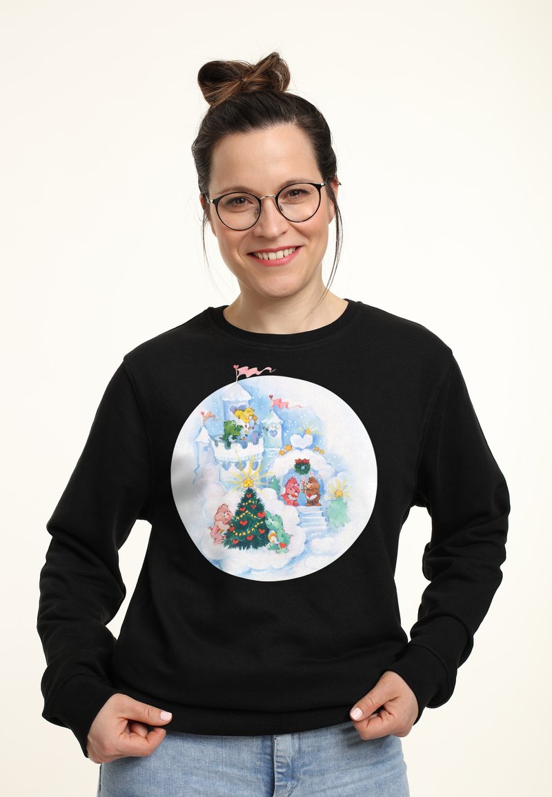 Felpa nera con una grafica circolare che presenta una scena invernale giocosa, un albero di Natale decorato e personaggi colorati in tenui toni pastello.