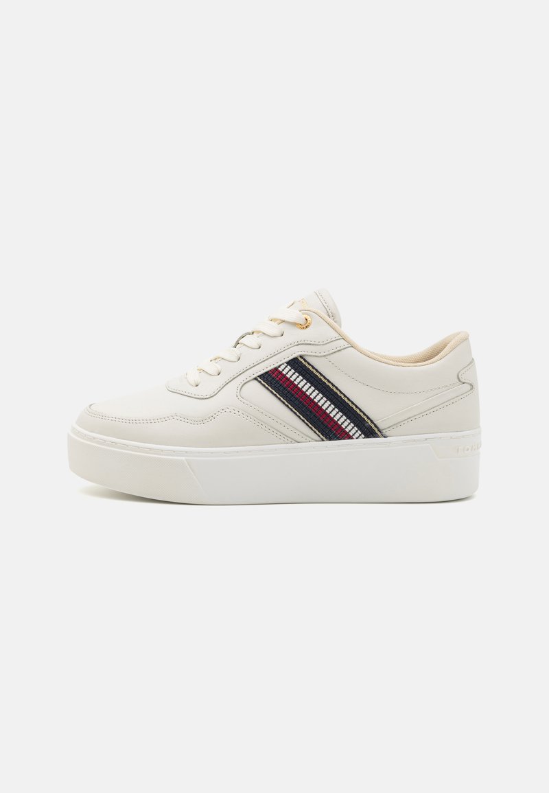 Hvite lær sneakers med teksturert overflate, som har en fargerik diagonalt stripeaccent i rødt og blått, samt en gummisåle.