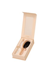 Hårborsteset i en blek persikofärgad ask. Innehåller en svart borste med borst och en vit kam. Asken har ett magnetiskt lock och en tom spegel.