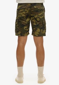 Pantalones cortos cargo en patrón de camuflaje, hechos de tejido duradero. Presentan dos bolsillos laterales, dos bolsillos traseros y un ajuste relajado.