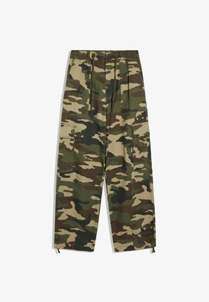Pantalon cargo camouflage avec taille élastique, cordons de serrage et poches à rabat sur les côtés, présenté à plat sur fond blanc.