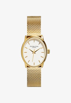 Goldfarbene Uhr mit einem Mesh-Armband, ovalem Gehäuse, weißem Zifferblatt und schlichten Stundenmarkierungen. Markenname "Victoria Hyde London" auf dem Zifferblatt angezeigt.