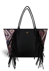Zwarte leren totebag met kleurrijke gestreepte stoffen zijkanten, lange franjes en een gouden logo accent aan de voorkant.