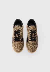 Leopardikuosisneakerit, joissa on mokkanahka päällä ja mustat nahkaosuudet. Varustettu mustilla nauhoilla ja kumipohjalla. Ylänäkymä.