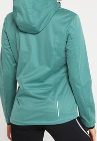 Teal, lätt jacka med huva, slät textur, har sidofickor och reflekterande detaljer, figursydd silhuett utformad för värme.