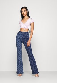 Jaded London FLOWER DISCHARGE PRINT WITH HEART BUTTON - Calças de ganga bootcut - blue