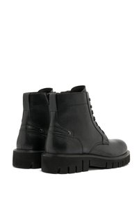 Czarne skórzane botki za kostkę o teksturowanym wykończeniu, z wiązanym designem, okrągłym noskiem i grubą gumową podeszwą dla zwiększenia trwałości.