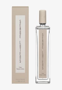 Eau de parfum in un flacone di vetro trasparente con un tappo cilindrico color sabbia. La scatola presenta un pannello beige e bianco con dettagli testuali.