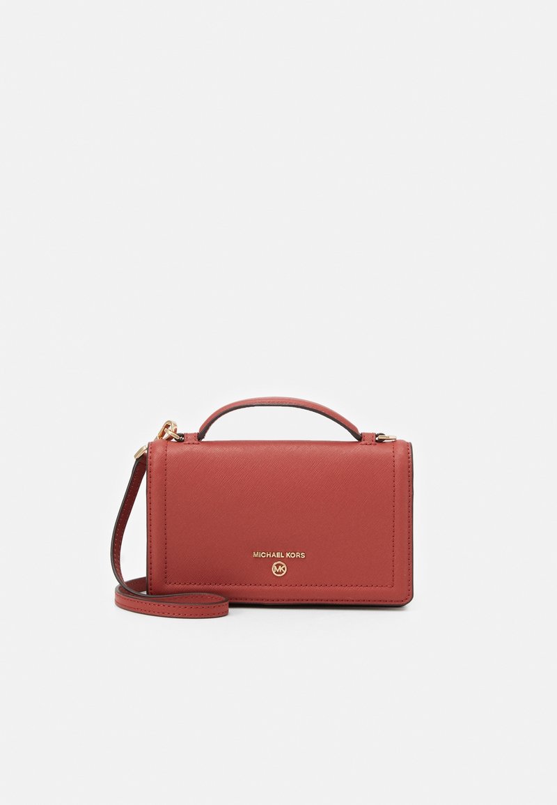 Sac à main en cuir rouge Michael Kors avec poignée supérieure, bandoulière amovible et emblème logo doré sur le devant.