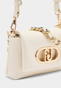 Weiße Kunstleder-Handtasche mit einer goldenen Kettenriemen und Beschlägen. Besitzt ein hervorstechendes goldfarbenes Logo-Detail auf der Vorderseite. Glatte Textur.