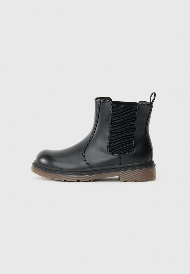 Bottines Chelsea noires en cuir lisse, avec des panneaux latéraux en élastique et une semelle en caoutchouc marron. Dotées d'une languette à l'arrière pour un enfilage facile.