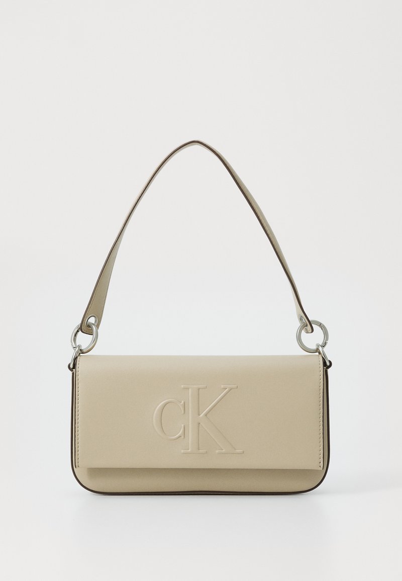 Borsa in pelle beige di Calvin Klein con logo embossato, forma rettangolare, profilo sottile e una tracolla con dettagli in metallo argentato.