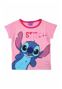 T-shirt rose pour enfants à manches courtes, avec un grand graphique représentant un personnage de dessin animé bleu et le mot "STITCH" en lettres majuscules et dans une police ludique.