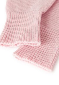 Tessuto a coste rosa tenue piegato, che mostra un motivo testurizzato e bordi soffici su uno sfondo bianco pulito.