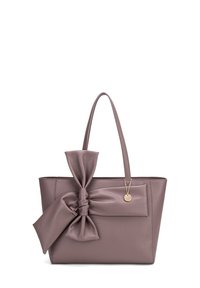 Borsa a tote in pelle di un tenue mauve, con un grande fiocco sul davanti e un piccolo tag metallico. Due manici robusti per il trasporto.