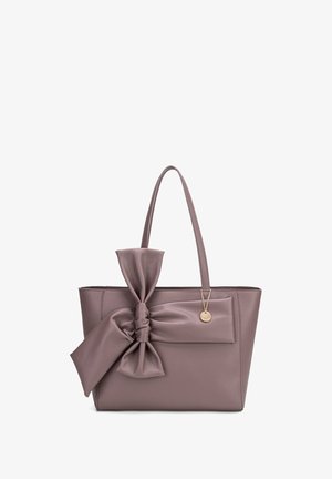 Borsa a tote in pelle di un tenue mauve, con un grande fiocco sul davanti e un piccolo tag metallico. Due manici robusti per il trasporto.