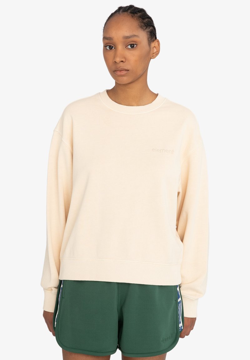 Cremfarbener Sweatshirt mit lockerer Passform, gerippten Bündchen und Saum sowie dezentem Logodetail. Kombiniert mit grünen Shorts mit seitlichen Akzenten.
