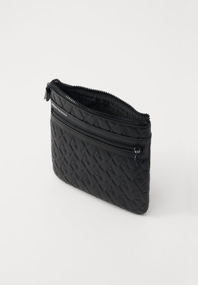 Pochette noire zippée en matériau texturé, présentant un motif géométrique, avec une poche zippée à l'avant et une fermeture zippée.