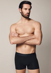 Czarne bokserki z miękkim elastycznym pasem w talii, na którym znajduje się nazwa marki "LANCERTO". Gładka tkanina, dopasowany krój, minimalistyczny design.