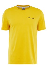 Yellow cotton t-shirt with a crew neck, short sleeves, and a small dark logo on the upper left chest. Smooth texture, casual fit.