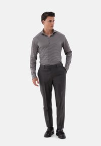 Grau gemustertes Button-Up-Hemd, slim-fit anthrazitfarbene Hose und schwarze Schuhe. Das Hemd hat ein dezentes Muster und lange Ärmel.