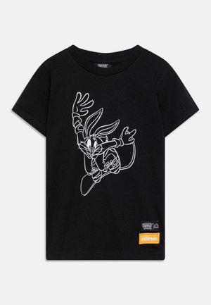 Black short-sleeve t-shirt with a white line drawing of Bugs Bunny skateboarding and Looney Tunes and ellesse brand patches at the bottom.