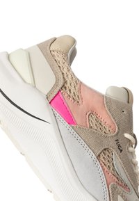 Sneaker con una toma beige, rosa e grigia che combina mesh e suede. Presenta una suola bianca chunky e una linea di accento nera.