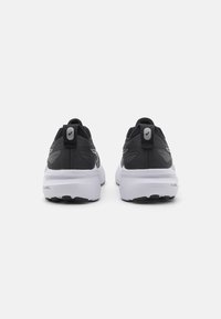 Zwarte sportieve schoenen met een gestructureerde bovenkant, witte tussenzool en zwarte buitenzool. Voorzien van een trekhaak en reflecterende accenten aan de achterkant.