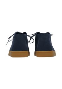 Botas de tobillo de ante azul marino con suelas de goma beige, con diseño de cordones y superficie texturizada. Parte trasera lisa con una silueta sencilla.