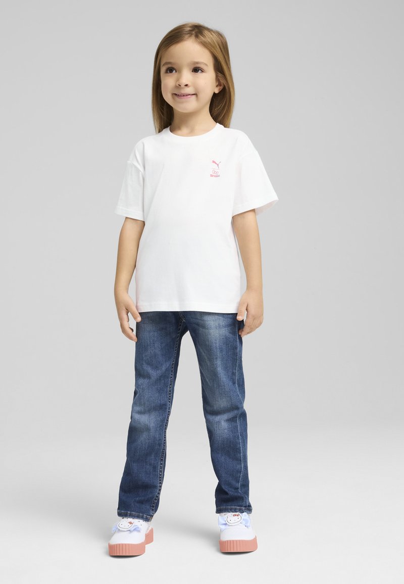 Hvid bomulds t-shirt med korte ærmer, pink logo på brystet, parret med blå denim jeans og multifarvede klipklapper.