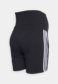 Svarta träningstights med hög midja, som har tre vertikala vita ränder på varje sida och en slät, elastisk textur.