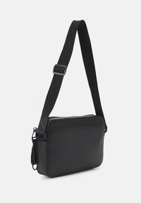 Borsa a tracolla rettangolare nera con tracolla larga regolabile e texture liscia, su uno sfondo bianco.