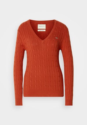 Roter Kabelstrickpullover mit V-Ausschnitt und langen Ärmeln. Verfügt über gerippte Bündchen und Saum sowie ein kleines Logo auf der linken Brust.