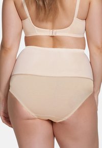 Beige high-waisted ondergoed van gladde stof met een golvende rand. Heeft een naadloos ontwerp en een brede, ondersteunende tailleband.