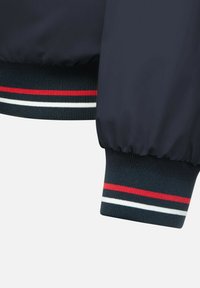 Cazadora bomber azul marino con puños acanalados, que presenta franjas rojas, blancas y azules. Tela suave y ligera con un corte relajado.