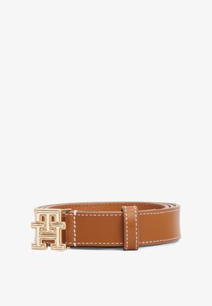 Bruine leren riem met witte stiksels en een goudkleurige, in elkaar grijpende "TH" logo gesp, opgerold en plat gelegd op een witte achtergrond.