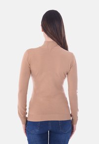 Maglione aderente beige con colletto alto a coste, maniche lunghe e orlo a coste. Texture morbida, design minimal e costruzione senza cuciture.