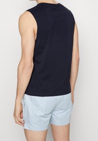 Mörkblå ärmlös topp med rund halsringning, tillverkad av bomull, kombinerad med ljusblå shorts. Har en avslappnad passform och rena sömmar.