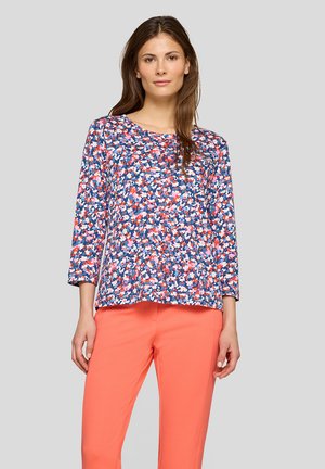 Blumenmuster-Oberteil mit Dreiviertelärmeln, das ein mehrfarbiges Muster aus Rosa, Blau und Weiß auf einem marineblauen Hintergrund zeigt.
