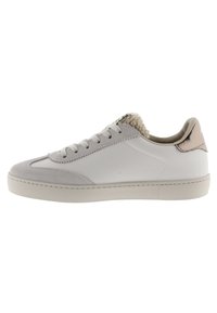 Sneaker bianco con accenti in suede, fodera in morbido pellicciotto, punta arrotondata e suola beige chiaro. Include chiusura con lacci e dettaglio metallico sul tallone.