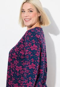 Dlouhý rukáv, námořnická modrá blůzka s květinovým vzorem v růžové barvě. Měkká tkanina, kulatý výstřih, uvolněný střih a jemně splývavá silueta.