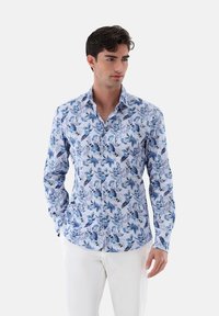 Camicia a maniche lunghe realizzata in tessuto con un motivo floreale blu su uno sfondo azzurro chiaro; design con bottoni, colletto e polsini.