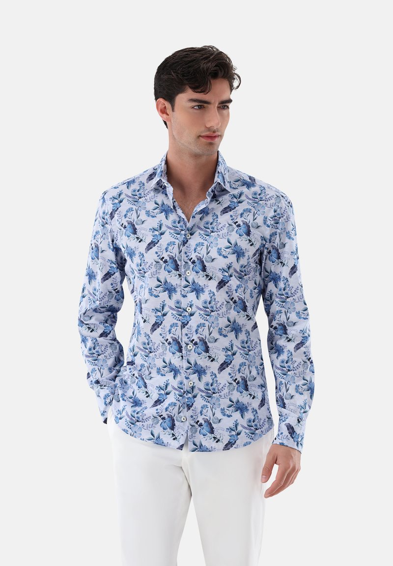 Camicia a maniche lunghe realizzata in tessuto con un motivo floreale blu su uno sfondo azzurro chiaro; design con bottoni, colletto e polsini.